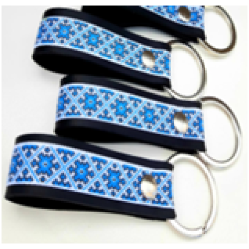 A leather keychain with a traditional sky-blue Ukrainian ornament