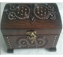 A carved handmade wooden casket, encrusted with metal and beads,