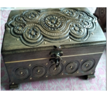 A carved handmade wooden casket, decorated with metal insertions,