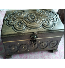 A carved handmade wooden casket, decorated with metal insertions,