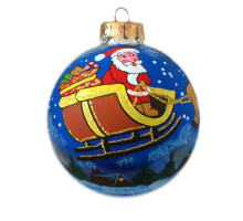 A blue handmade glass Christmas tree ball with an artistic painting, embellished with glitter "Santa on sledges over a village", 3,25 inches