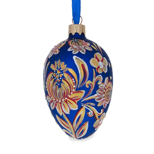 A blue handmade glass Christmas tree egg shaped pendant with a bright golden flower made in Petrykivskyi painting technique style, 2.6 inches