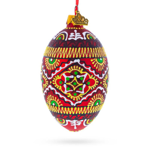 A red handmade glass Christmas tree egg shaped pendant with a Ukrainian traditional ornament, embellished with glitter, 2.6 inches