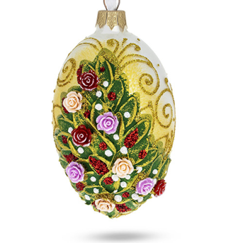 A white handmade glass Christmas tree egg shaped pendant with a relief painting of a bouquet of roses, embellished with glitter, 2.6 inches