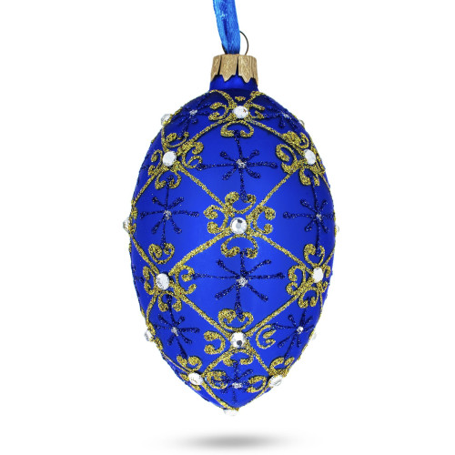 A blue handmade glass Christmas tree egg shaped pendant with a traditional ornament, embellished with glitter and precious stones, 2.6 inches